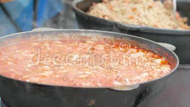 铸铁锅中的食物，志愿者在木炉上准备<strong>饭菜</strong>，难民营，为乞丐准备热汤